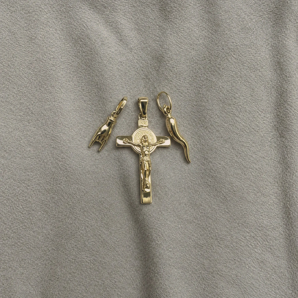 18k Italian Gold Crucifix Pendant laying along with Italian Horn and Hand.