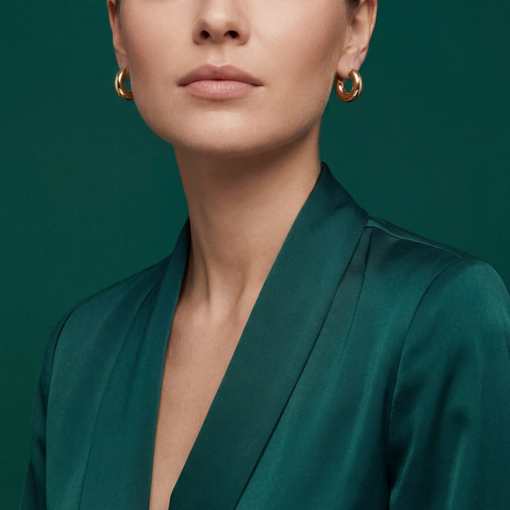 Woman wearing 18k gold bold dome chunky hoop earrings