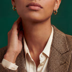 Woman wearing classic medium 18k gold tube hoop earrings