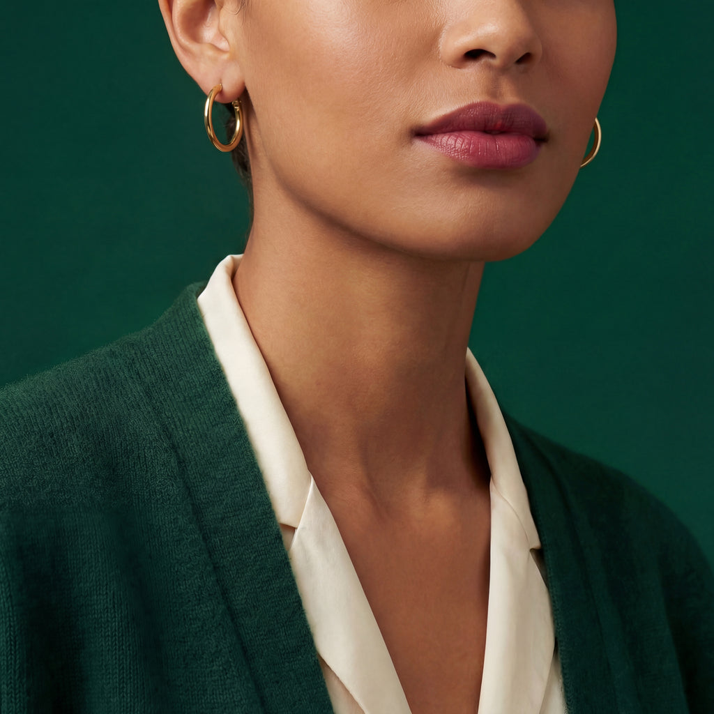 Woman wearing slender 18k gold thin tube hoop earrings